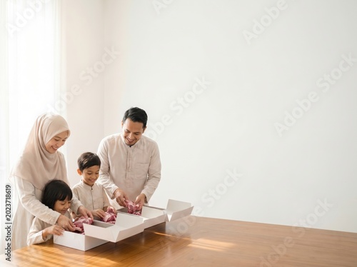 Muslim family packing qurban meat together during Eid al Adha celebration at home