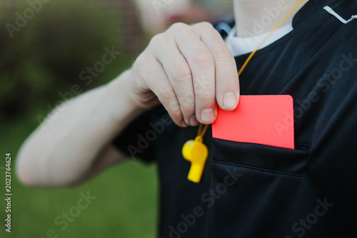 Photos Soccer referee taking a red card from pocket during a football match
