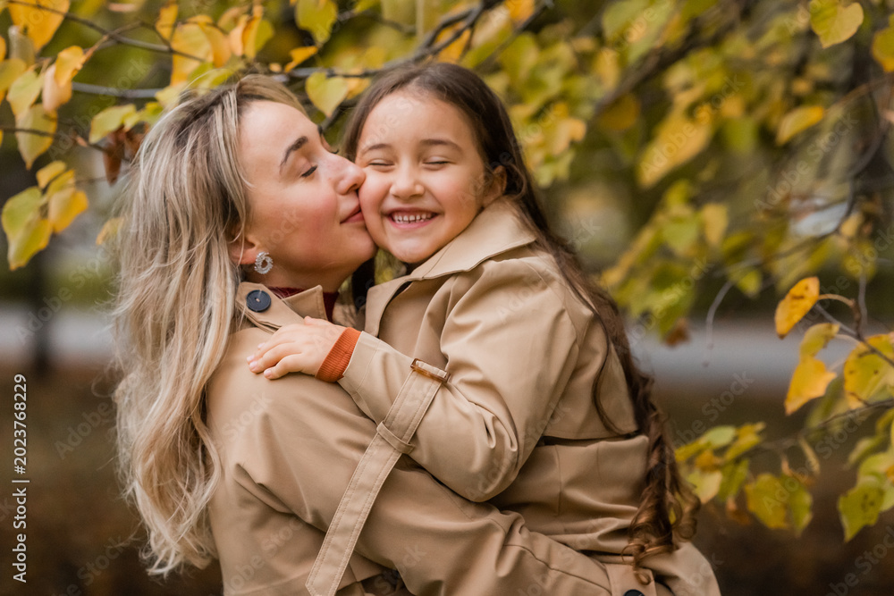 Fototapeta premium mother and daughter walking in the park in autumn