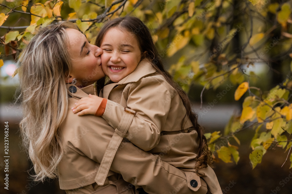 Fototapeta premium mother and daughter walking in the park in autumn