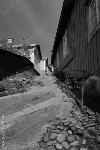 Ruelle pavée d’un village finlandais en noir et blanc
