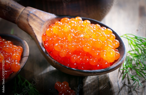 Икра красная-зернистая, полезный и вкусный морепродукт в деревянной ложке.