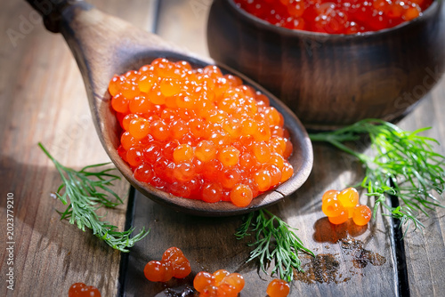 Икра красная-зернистая, полезный и вкусный морепродукт в деревянной ложке.