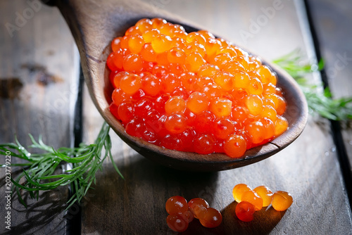 Икра красная-зернистая, полезный и вкусный морепродукт в деревянной ложке.