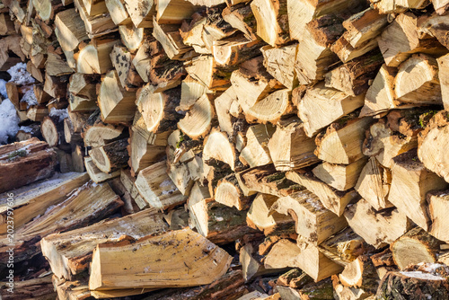 Chopped firewood stacked in a woodpile. Close-up