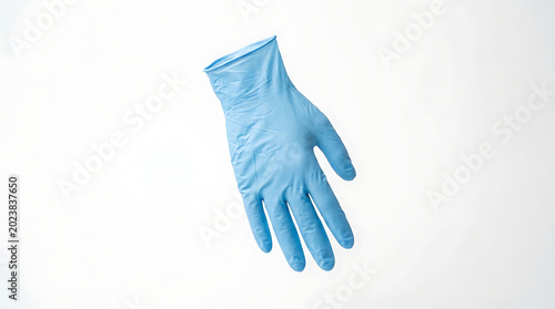 Protective blue nitrile examination glove for medical and dental use isolated on a white background emphasizing hygiene, sterile procedure, and safety protocols in clinical and surgical settings.