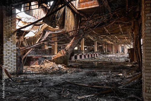 Tableau sur toile Charred metal structures and debris litter the floor of a large commercial building following fire damage
