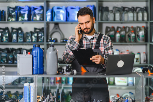 Fotografie Auto parts store employee assisting customer on phone