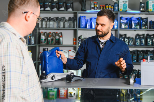 Employee assisting customer with motor oil purchase