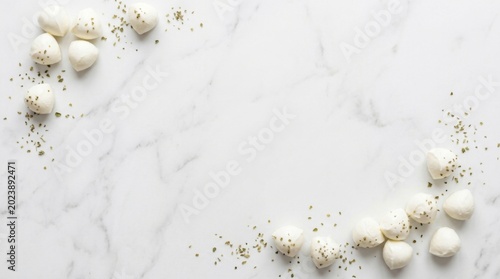 Mini mozzarella balls with dried herbs on marble background flat lay