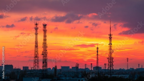 Sunset skyline with silhouetted communication towers. Artificial intelligence image