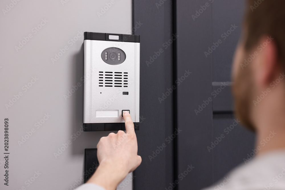 Naklejka premium Man pressing button on intercom panel indoors, closeup