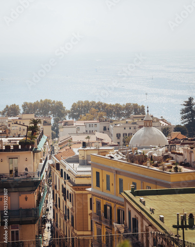 View over historic city rooftops and apartment buildings toward the Mediterranean sea in Naples Italy