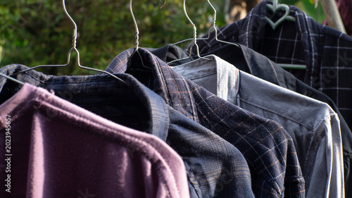 Obraz na płótnie Washed shirts on clothesline, air-drying naturally outdoors in sun, a sustainabl