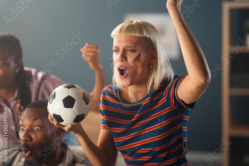 Fotografi A group watches a soccer game in a living room