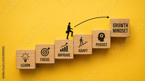 Businessman climbing wooden blocks with growth mindset and success strategy steps learn focus improve adapt persist