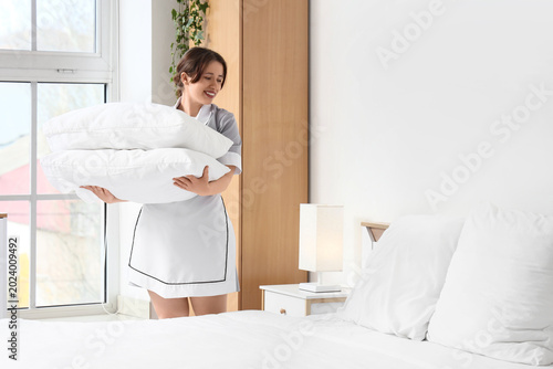 Young chambermaid with stac...