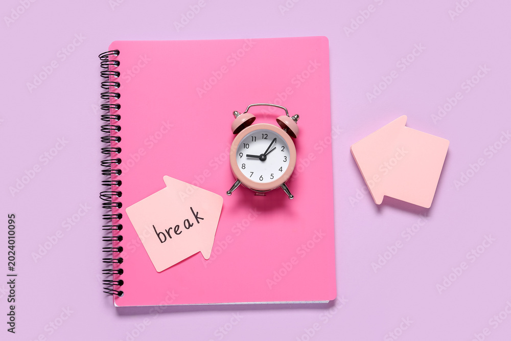 Fototapeta premium Alarm clock with notebook and word BREAK on sticky note against lilac background. Time management concept