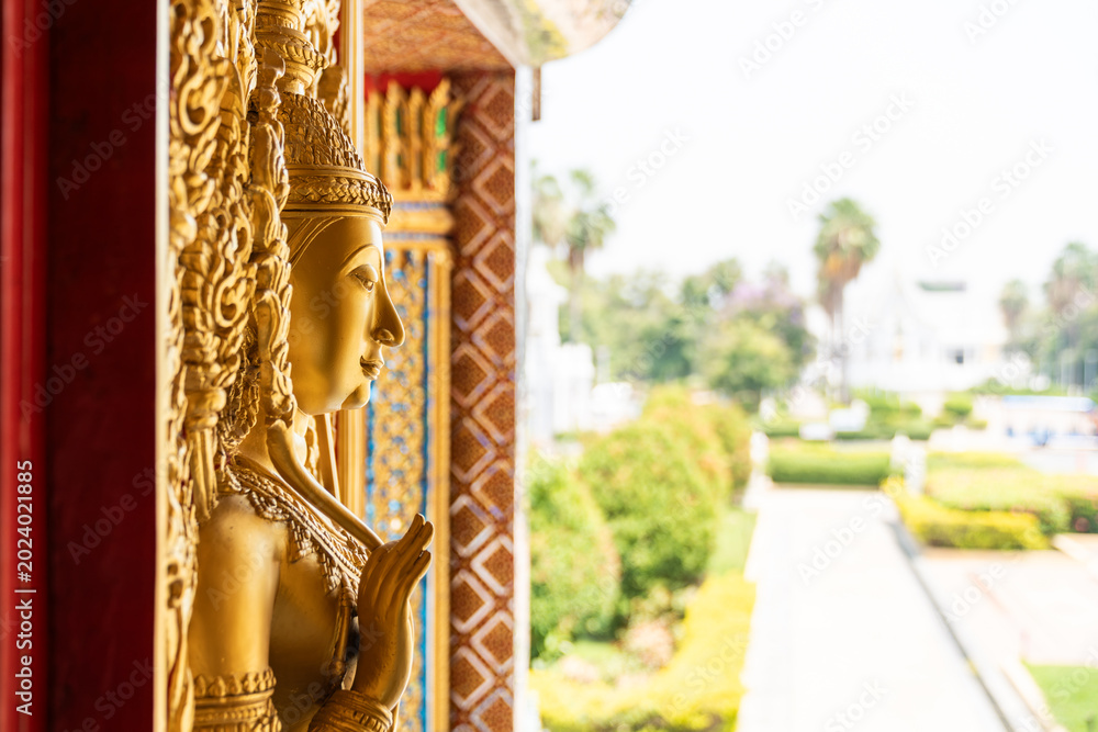 Fototapeta premium High relief guardian figure temple door Prasat Thong Kham Kanchanaphisek golden palace Wat Chantharam, ThaSung UthaiThani Thailand gilded ornament mirrored mosaic.