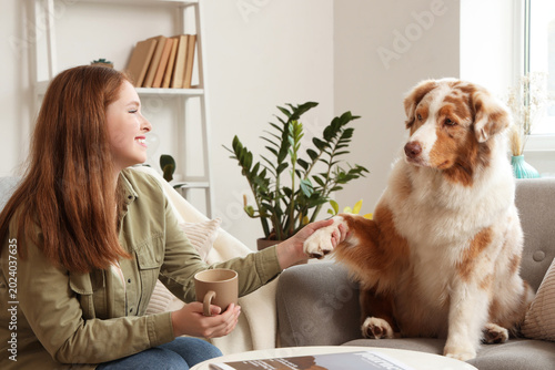 Young woman holding paw of ...