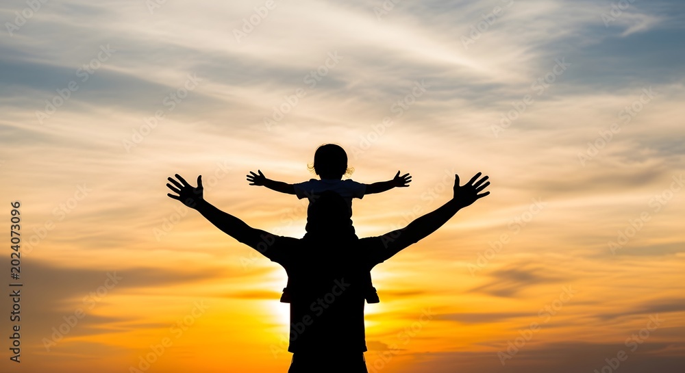 Fototapeta premium Silhouette of person celebrating against sunset sky