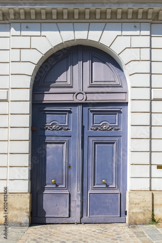 Paris, a wooden door rue de Babylone, typical building in the 7th arrondissement, a luxury district
