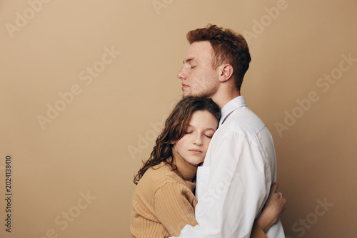 Schilderij op canvas Young couple embraces tenderly with closed eyes, expressing love and comfort