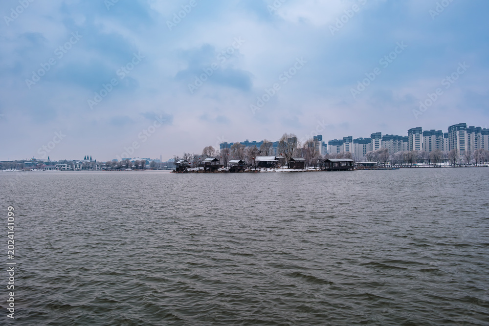 Fototapeta premium Snow Scenery of Hailong Lake Scenic Area in Meihekou, Jilin Province, China – Urban Ecological Park and Lakeside Landscape Covered in Late Spring Snow – April 4, 2026