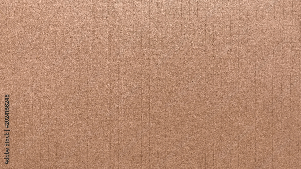 Fototapeta premium Close-up brown kraft cardboard with fine grain and layered texture. Light and shadow highlight the rhythmic ridge structure. Great for sustainable or handcrafted visual themes.