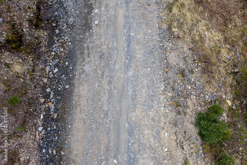 Aerial View of Rugged Gravel Road and Rocky Trail Through Forested Hills in BC Canada