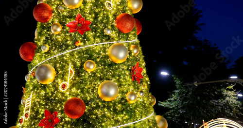 Bild auf Leinwand Decorated Christmas tree glows brightly with ornaments and musical notes at night