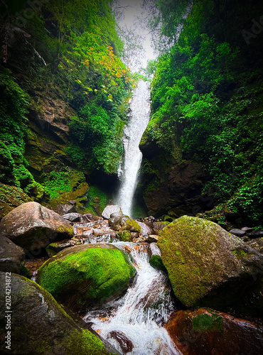 Kanchenjunga Waterfall in West Sikkim, India - A majestic, gushing cascade flowing through lush Himalayan greenery and mossy rocks.
