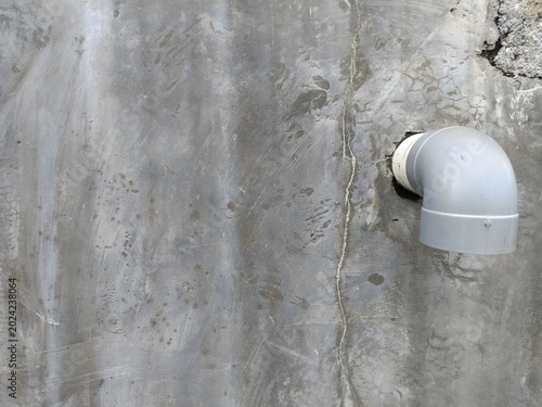 Valokuva Gray plastic pipe protrudes from a weathered concrete wall in thailand