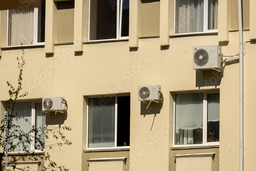 outdoor unit of air conditioner compressor is installed outside house on facade office or residential building. Air conditioning units HVAC on wall of building. indoor cooling in heat. Global warming.