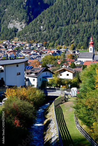 Blick über den Radurschlbach auf den Ortskern von Pfunds mit Pfarrkirche, Tirol