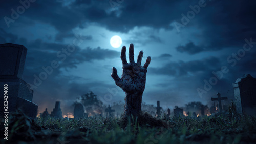 Zombie hand rising out of a graveyard in spooky night, a Halloween concept.