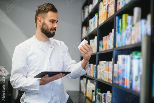 Bild auf Leinwand Pharmacist analyzing medicine bottle using digital tablet in pharmacy
