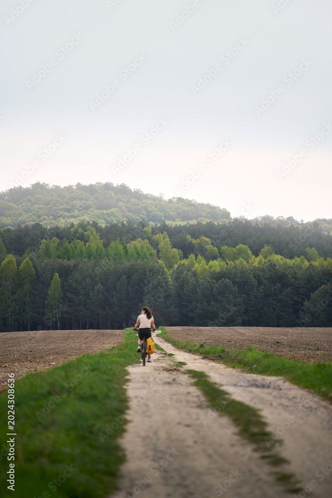 Obraz premium Happy female biker in rural nature
