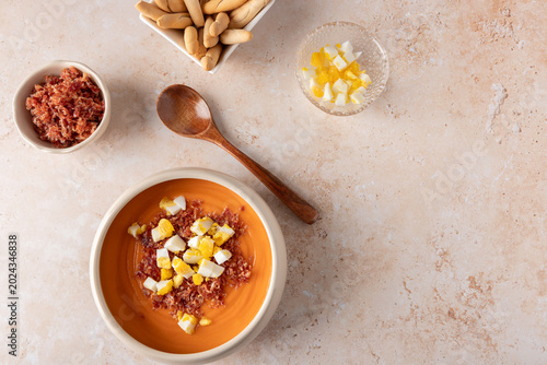 Foto Traditional homemade salmorejo in beige bowl with serrano ham, chopped boiled eg