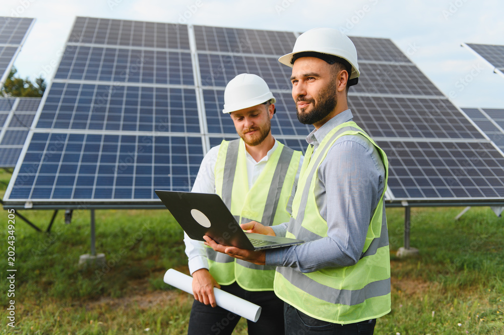 Fototapeta premium Engineers discuss renewable energy project with solar panels