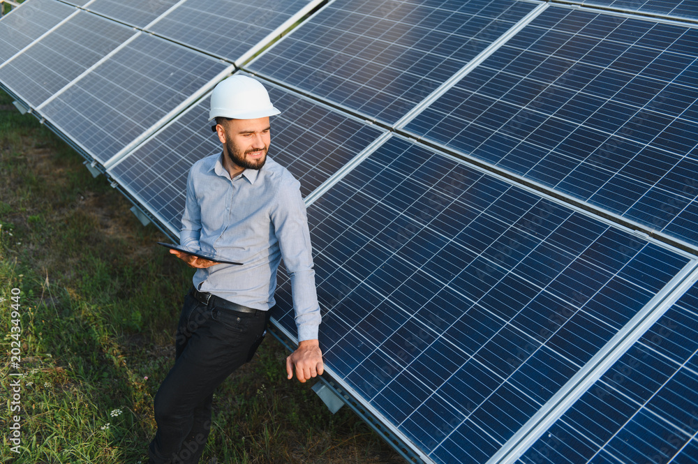 Fototapeta premium Engineer man checking solar panels using tablet