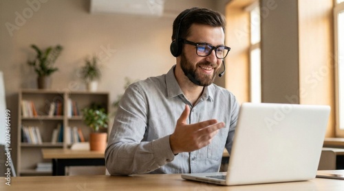 Indian business man speaking having virtual meeting on laptop. Professional remote online customer service support manager wearing headset talking consulting on video call at home office call center.