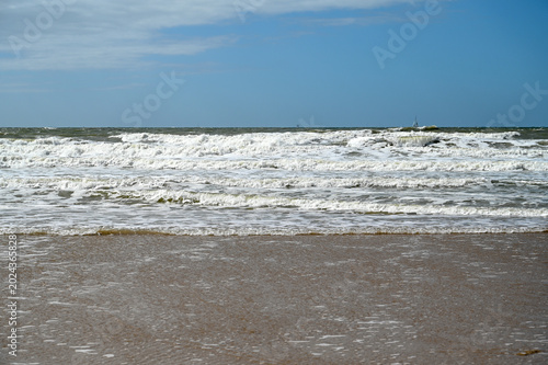 North Sea sandy beach near Scheveningen in The Hague Netherlands. Sea waves. Beautiful sandy coastline. 