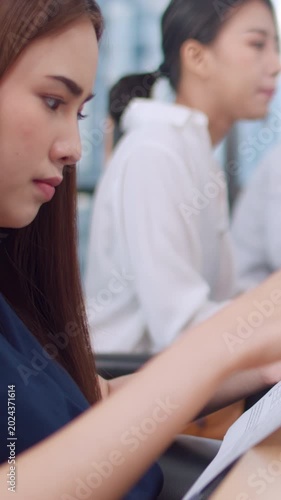 Vertical Screen : Collaborative group of multicultural business people in smart casual wear communicating and using technology while working together in office. Asia team of young professionals work.