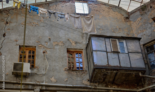 Fotografie Weathered facade of an old residential building with laundry and makeshift balco