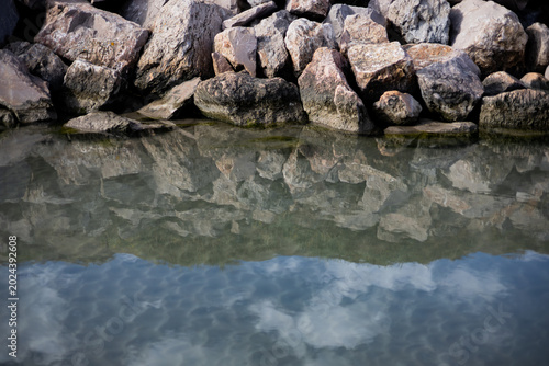 A section of a river with a breakwater in the background