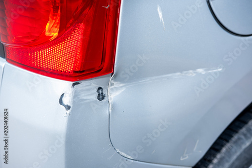 фотографія Vehicle bumper displaying deep scrapes and paint loss from an accident, highligh
