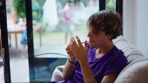 Bild auf Leinwand Young man lighting a cannabis joint at home, relaxing in an indoor common area