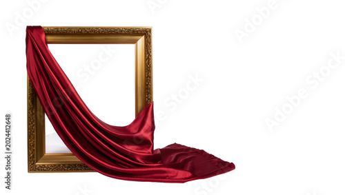 Obraz na plátne Ornate golden picture frame draped with flowing red satin fabric, isolated on tr