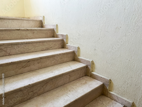 Fotografia Marble staircase with a light textured wall, emphasizing architectural detail, p